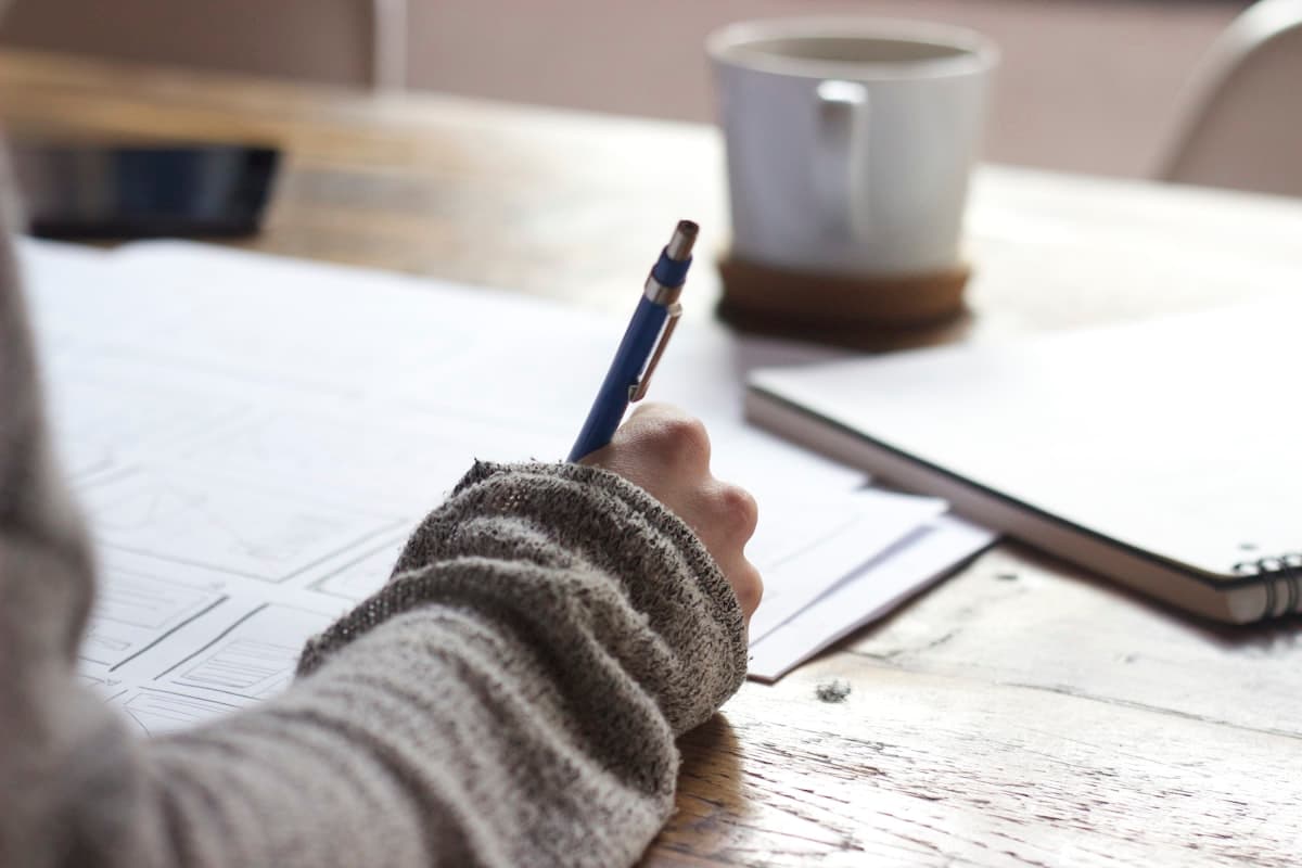 A student writing out practice answers by hand